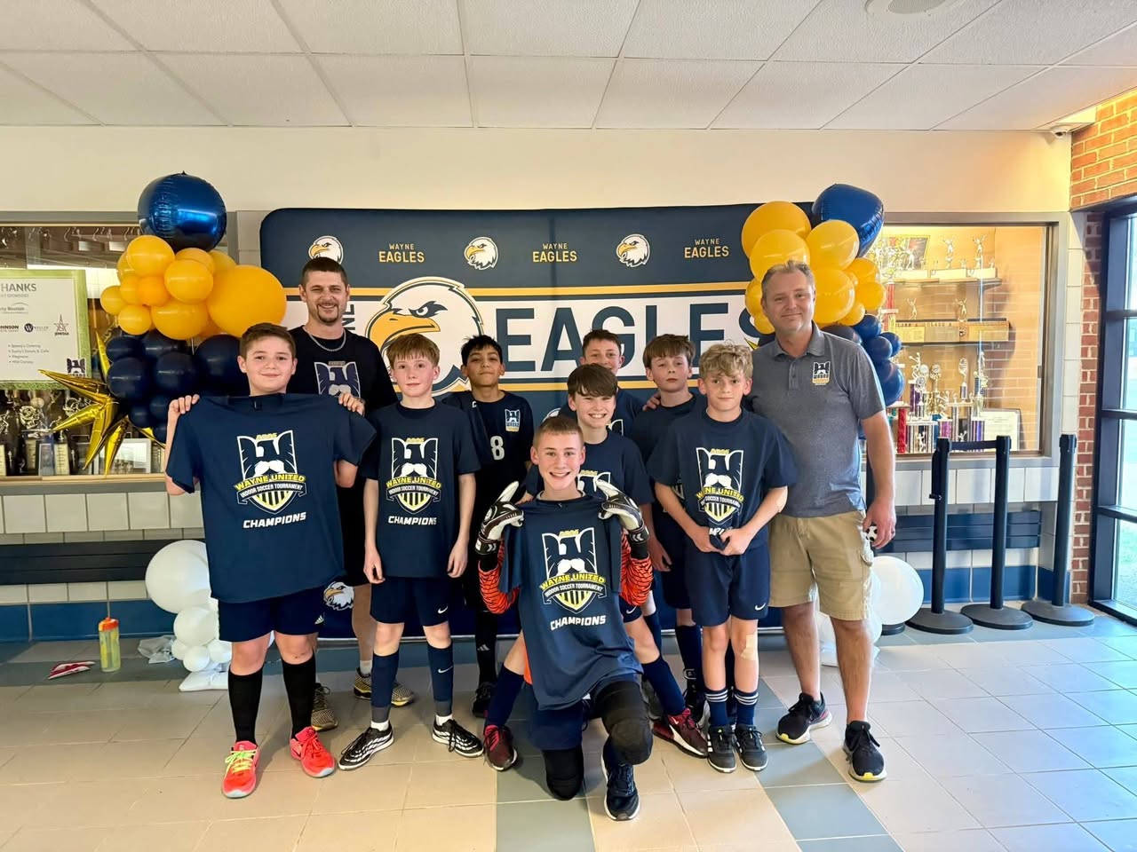 Players in Wayne United indoor tournament champions shirts, the keeper holding his gloves up