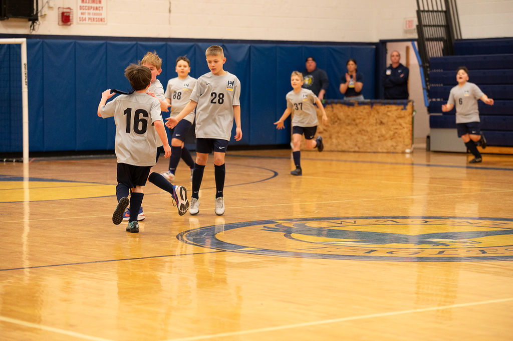 Wayne United players chasing the ball during an indoor game