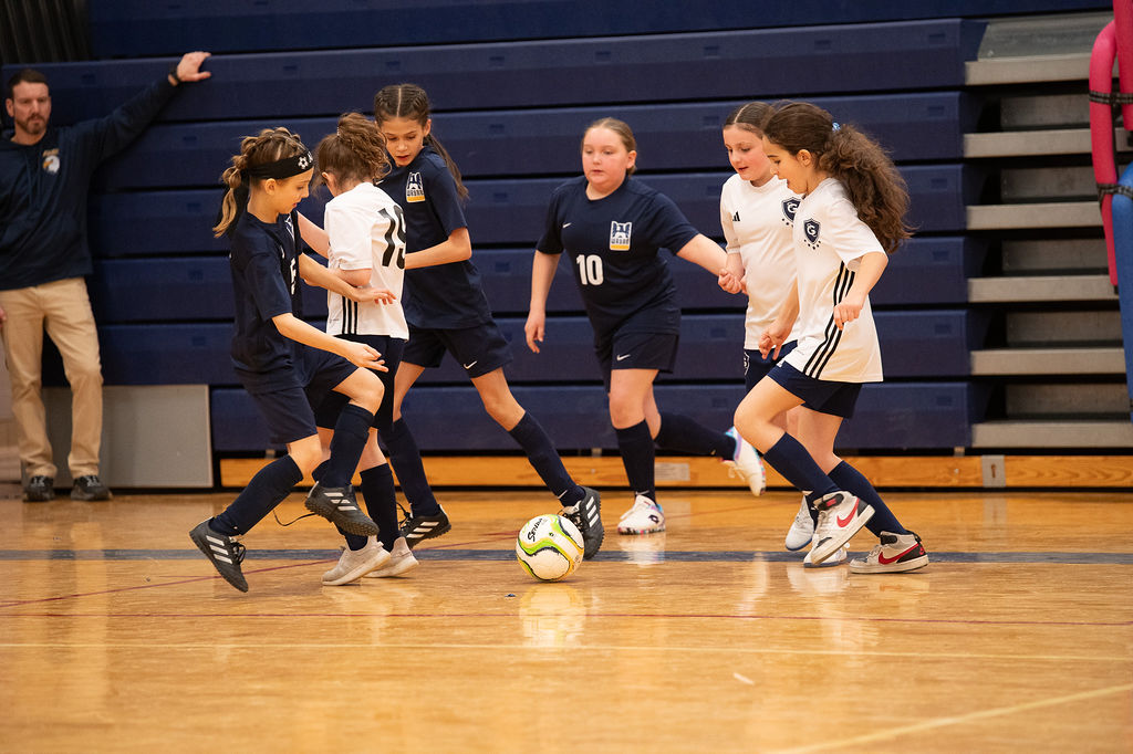 Wayne United player shielding the ball on the gym floor