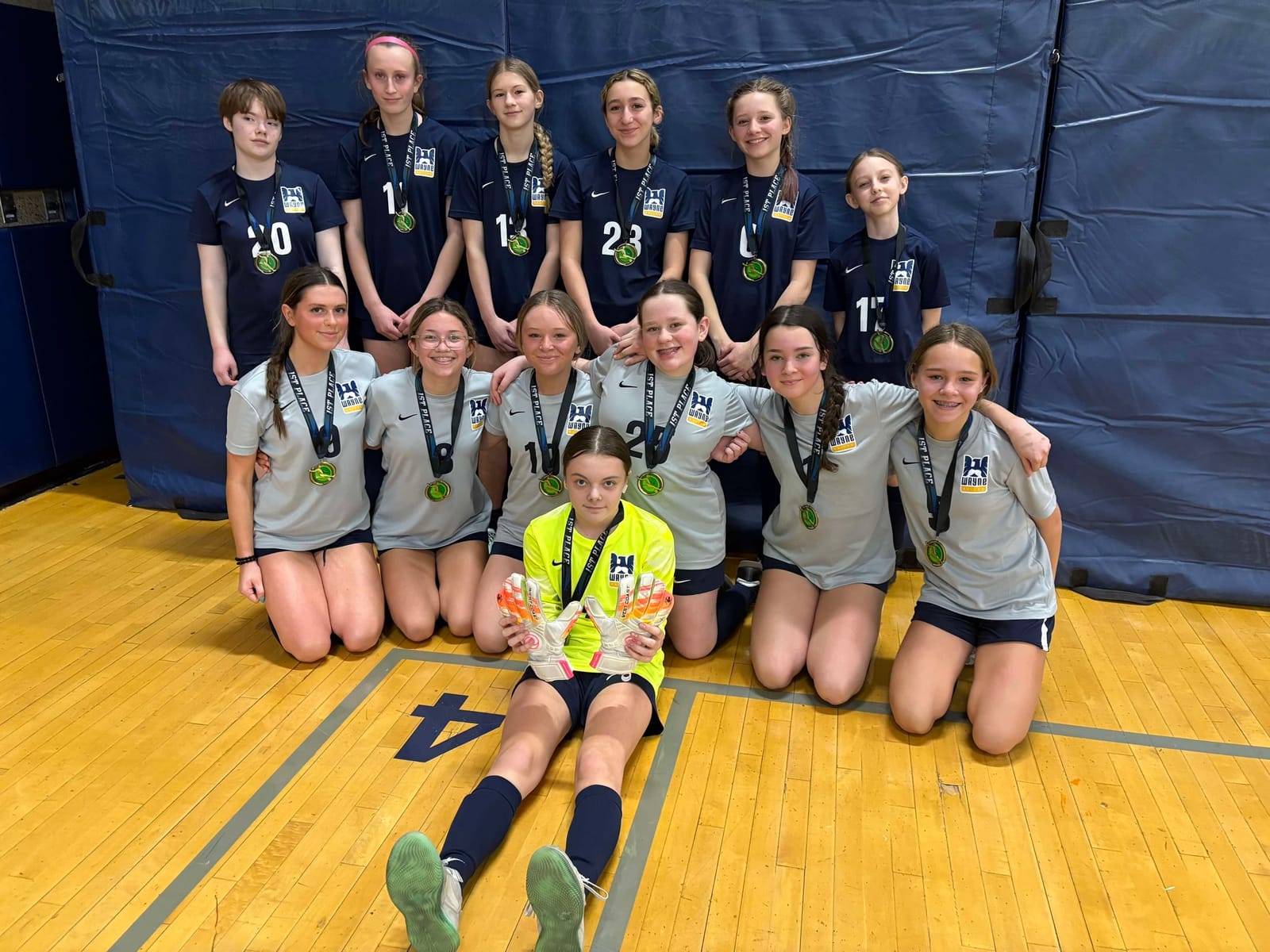 Girls team in Wayne United kit with their first place medals